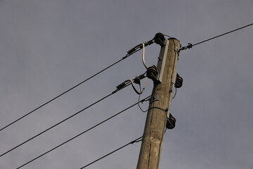 A tall wooden pole with wires on top of it