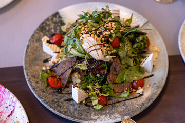 A plate of food with a salad on top of it