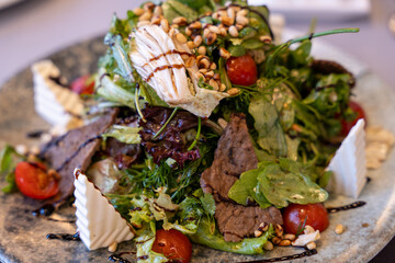 A salad with meat and vegetables on a plate