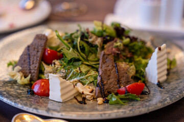 A plate of food with a salad and meat on it