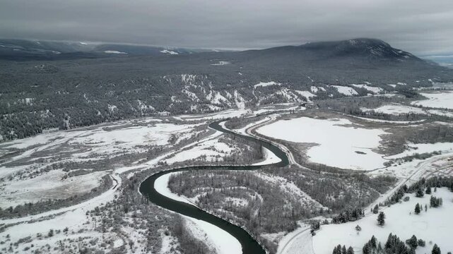 Aerial: Columbia River valley in winter snow under heavy grey overcast
