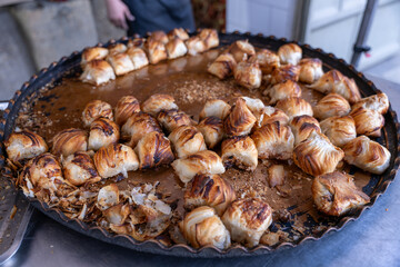 A tray of food with a variety of pastries and a few pieces missing