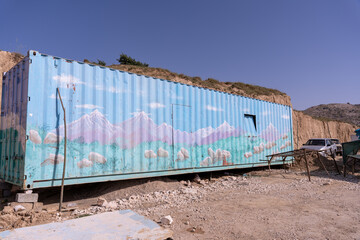 Fototapeta premium A blue container with mountains painted on it