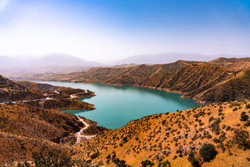 Naklejka premium A beautiful lake surrounded by mountains and a dry, barren landscape