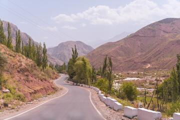 A winding road with a mountain in the background