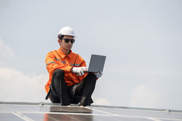 Male engineer checking solar cell or photovoltaic cell by computer laptop installed on the roof of...