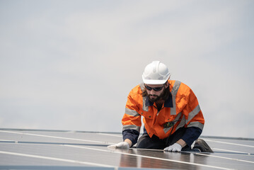 Obraz premium Male engineer checking solar cell or photovoltaic cell by electronic device installed on the roof of the factory. Technician worker repair or inspect the system. Industrial renewable energy concept