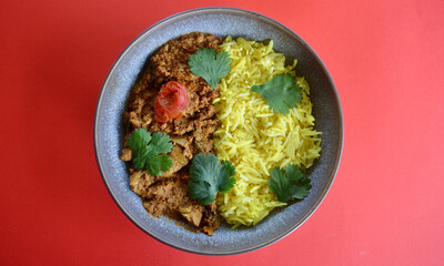 Ashoka chicken with saffron rice and coriander leaves.