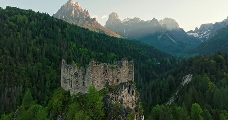 Aerial view of Castel belfort in Dolomite Alps, Italy. The ruins of a fortress on top of a mountain in the middle of a mountain forest in a beautiful natural landscape. High quality 4k footage - Powered by Adobe