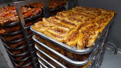 Cooked pork ribs are meticulously arranged on a perforated surface, signifying the culinary process in an industrial kitchen.