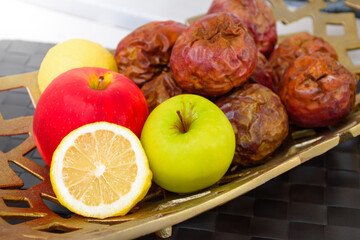Many colorful fresh ripe fruits is lemon with apple and passion fruit in a golden yellow basket on wooden table for healthy food and vitamin C concept. Set of healthy fruits and alternative foods.