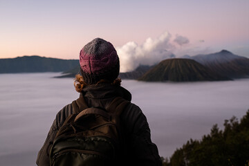 A young girl, a traveler, of European appearance, wearing a knitted hat, admires the stunning view...
