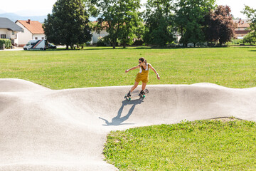 Woman surfskating or skateboarding on a pumptrack. Extreme sports, health and exercise concept. Smiling girl practicing turns on a skateboard. © Glyph_stock