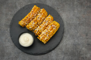 Spicy corn ribs with barbecue sauce and grated cheese

