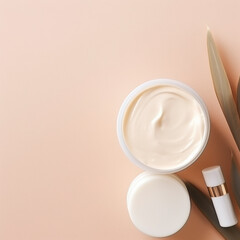 Face and body cream in white jars and a serum bottle lying on a beige background with decorative green leaves