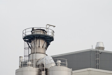 elements of a dairy factory against a background of gray sky
