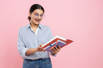 Beautiful girl in casual shirt holding organizer reading notes in paper notebook