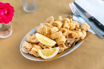 Fried fish, calamari dish, squid, fried prawns. Rustic table typical of taverns.
