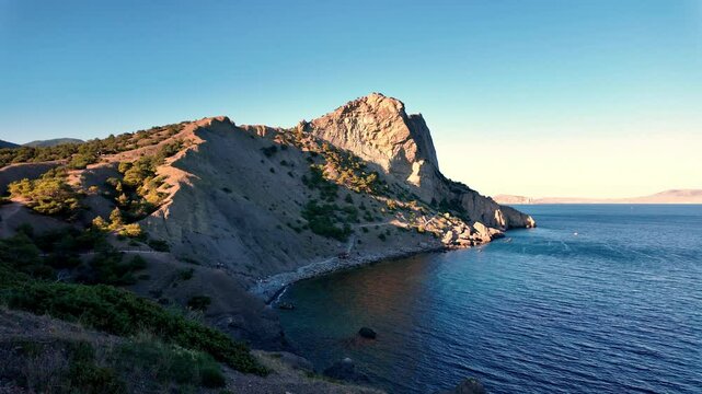 A breathtaking view of a rocky coastline with blue water and a clear sky in New World.