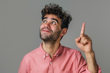 The Asian man points for space, advertising, and happiness on a grey studio background. Japan, male and guy with confident and relaxed gesture for product placement, branding, or Gen Z.