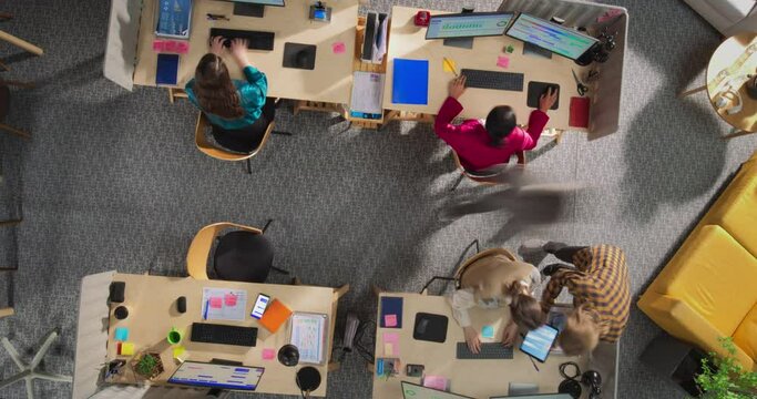 Top Down View in Timelapse: Multiethnic Team Of Managers Working in a Creative Agency Office. Corporate Workspace With Colleagues Talking, Discussing Ideas, Using Desktop Computers, and Walking Around