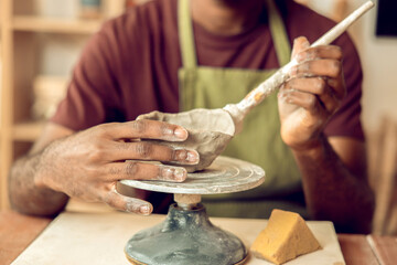 Male sculptor working on a new clay mug in his office