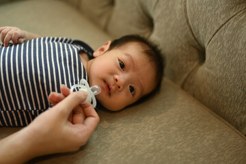 Cropped shot of mother giving pacifier cute little newborn baby. Child care concept