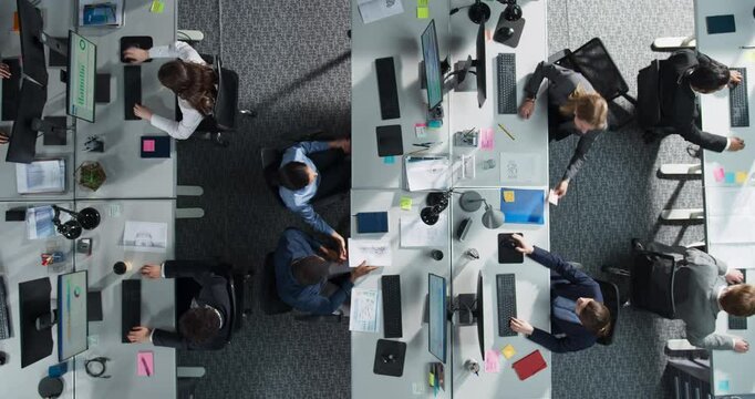 Top Down View: Diverse Team Of Professionals in an Office, Working on Desktop Computers With Documents And Reports. Workspace Of Modern Fintech Startup or Investment Fund With Managers And Analysts.