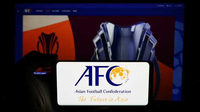 Stuttgart, Germany - 06-25-2024: Person holding cellphone with logo of association Asian Football Confederation (AFC) in front of webpage. Focus on phone display.