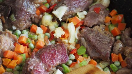 Stir-fry meat and vegetables in an iron skillet. wok stir fry with selective focus