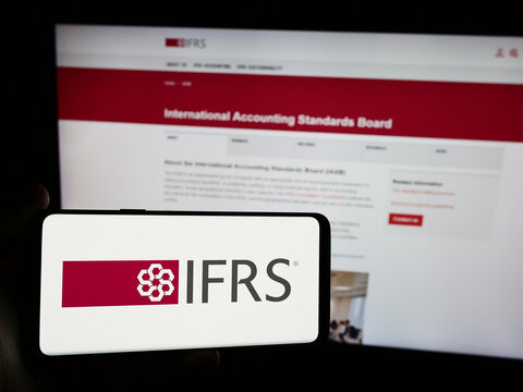 Stuttgart, Germany - 06-26-2024: Person holding smartphone with logo of International Financial Reporting Standards Foundation (IFRS) in front of website. Focus on phone display.