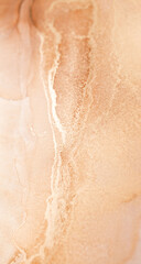 A close-up of abstract art featuring a mix of warm beige and brown hues. Delicate white streaks flow through the center, creating a mesmerizing and organic pattern