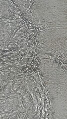 Trendy summer nature banner. Defocused liquid clear water surface texture with splashes bubbles with copy space. Water waves in sunlight background.	
