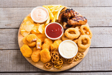 Onion rings , nuggets grilled wings , french fries mix of snacks and sauces . Beer board