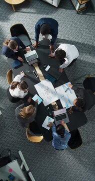 Vertical Screen Zoom Out Top Down View: Diverse Team Of Business Professionals With Laptops Entering The Conference Room And Sitting Behind Table To Discuss Financial Data, Project Mindmap in Office.