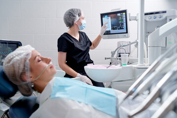 Dental surgery in modern dental clinic.. Woman patient is waiting for operation in the dentist...