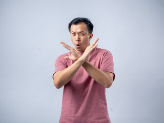 A man in a pink shirt crosses his arms in front of him with a disapproving expression, as if saying...