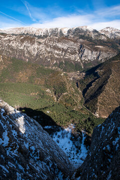 A breathtaking view captures the expansive snowy mountain ranges seen from a narrow valley, highlighting the stunning depth and rugged beauty of the natural environment in Pedraforca in Spain