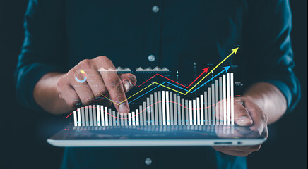 A businessman analyzes sales growth data on a virtual screen, focusing on digital online marketing,...