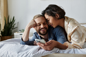 A loving couple spends a relaxing morning at home, cuddling in bed and enjoying each others company.