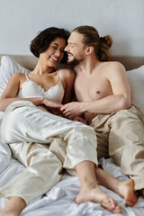 A couple shares a tender moment of laughter while lying in bed together.