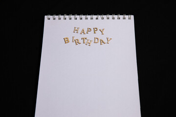 Leeres Papier mit Schriftzug HAPPY BIRTHDAY aus Holz
