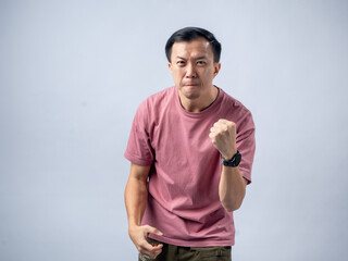 A man in a pink shirt raises both fists in a celebratory gesture, his face beaming with excitement...
