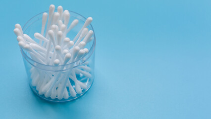 Plastic white cotton bud isolated on blue background, Plastic cotton swabs or cotton buds are on blue background, Plastic box with plastic white cotton bud with copy space.
