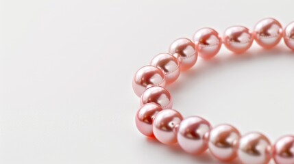 Obraz premium Pink pearl necklace displayed against white background with room for text