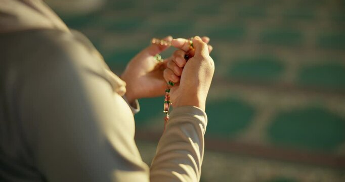 Muslim, person and hands with tasbih for prayer, dua or worship in dhikr or remember of Allah, god or creator at mosque. Closeup of islam or moslem praise with beads for glorification at temple