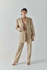 A woman wearing a beige suit and heels poses for a portrait.
