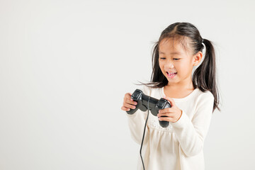 Asian happy portrait young kid girl smile lifestyle games technology holding joystick game playing on hands studio shot isolated white background with copy space, kindergarten child relaxation time © sorapop