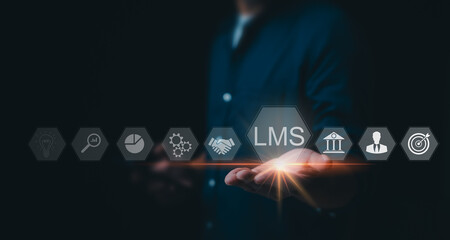 concept of a learning management system (LMS), a businessman touches a virtual screen displaying LMS icons, encompassing lessons, online education, courses, applications, and e-learning