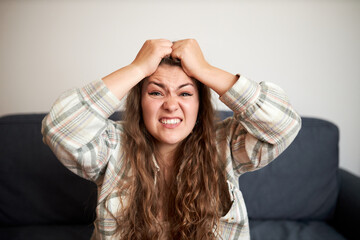 Portrait of young frustrated angry disappointed woman pulling her hair after her favorite team lost...